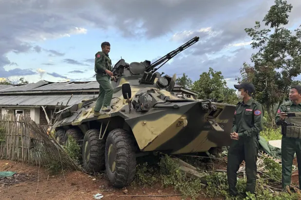 مسلّحون من مجموعة معارضة مع عربة مدرّعة غنموها من الجيش في شمال ميانمار (أ.ب)