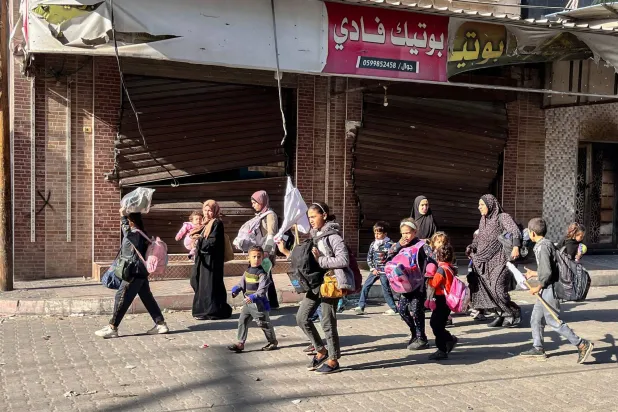 فلسطينيون يهربون سيراً من بيت لاهيا في شمال قطاع غزة وسط استمرار القصف الإسرائيلي (أ.ف.ب)