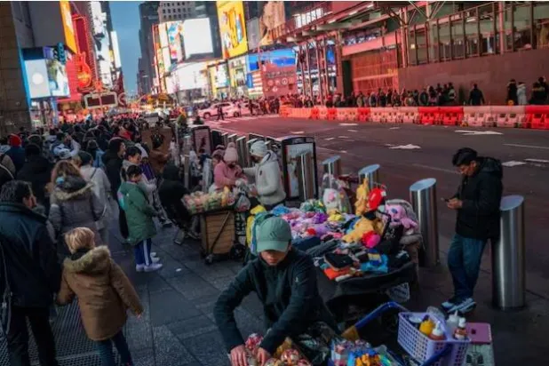 يعرض الناس البضائع للمشاة في ساحة تايمز سكوير بنيويورك (رويترز)
