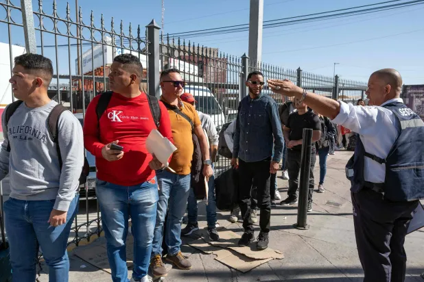 مهاجرون يستمعون إلى التوجيهات قبل عبور الحدود من المكسيك إلى إل باسو بولاية تكساس الأميركية (أ.ف.ب)