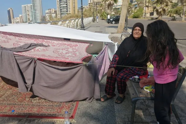 لمياء فرحات إلى جانب خيمتها في منطقة الرملة البيضاء في بيروت (الشرق الأوسط)