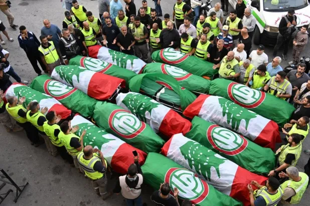 İsrail'in Barja kasabasına düzenlediği saldırıda hayatını kaybeden 16 kişi için Lübnan'ın güneyindeki Sur kentinde düzenlenen cenaze töreni öncesinde yas tutanlar (EPA)
