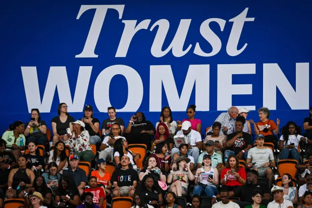 لافتة مكتوب عليها «ثقوا بالنساء» فوق مؤيدين لنائبة الرئيس الأميركي كامالا هاريس في هيوستن (أ.ف.ب)