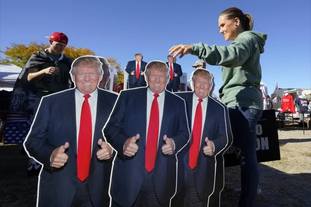 مؤيدة لترمب تتفقد بضاعة انتخابية قبل تجمّع له في سايلم بولاية فرجينيا 2 نوفمبر (أ.ب)