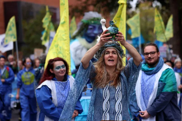 متظاهرون بريطانيون يرتدون ملابس باللون الأزرق يطالبون بمياه نظيفة خارج البرلمان في لندن (إ.ب.أ)