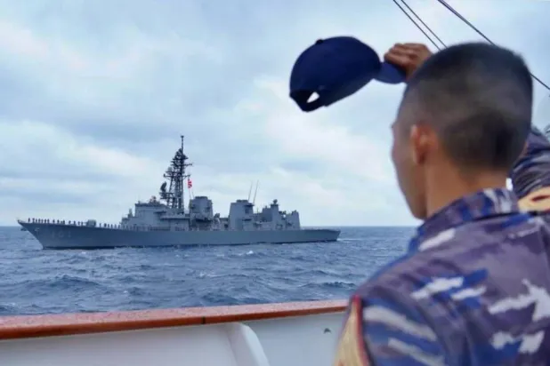 أحد عناصر البحرية الإندونيسية يلوح بقبعته لسفينة أخرى خلال إحدى التدريبات (حساب البحرية الإندونيسية عبر منصة «إكس»)