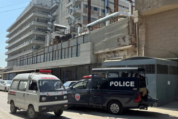 Karaçi’de iki Çin vatandaşının vurularak yaralandığı fabrikanın önündeki polis arabası ve ambulans (Reuters)