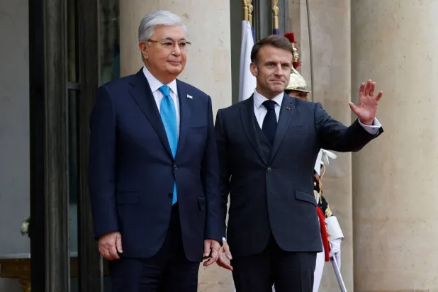 الرئيس إيمانويل ماكرون والرئيس قاسم جومارت توكاييف على مدخل قصر الإليزيه بمناسبة زيارة الدولة التي يقوم بها الثاني إلى فرنسا (أ.ف.ب)