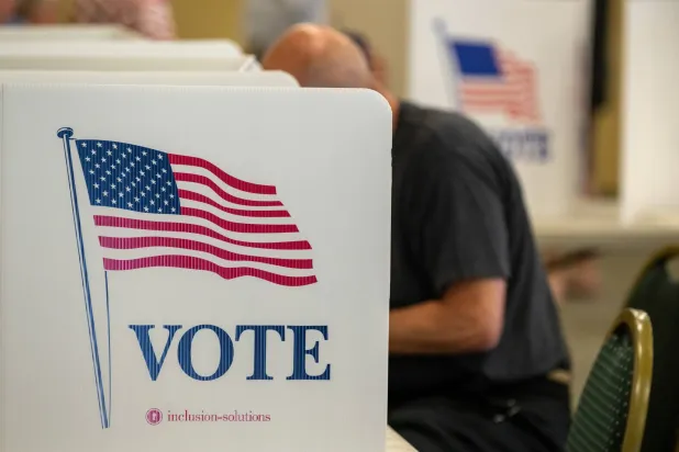 ناخب يدلي بصوته داخل مركز اقتراع في بنسلفانيا (إ.ب.أ)