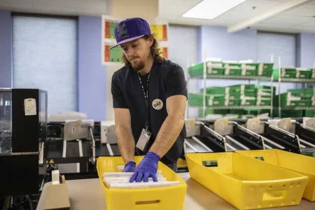 موظف يعمل على فرز بطاقات الاقتراع في دنفر بالولايات المتحدة (أ.ب)
