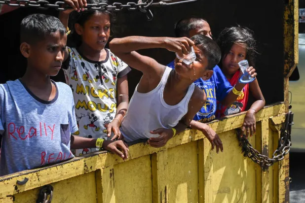 لاجئون من الروهينغا يجلسون داخل شاحنة وسط عملية نقلهم من إقليم إندونيسي الى آخر (أ.ف.ب)