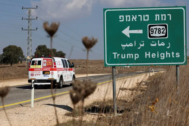 سيارة إسعاف تمر أمام لافتة طريق تشير إلى مستوطنة «رمات ترمب» (مرتفعات ترمب) في مرتفعات الجولان في يوم الانتخابات الرئاسية الأميركية 5 نوفمبر 2024 (رويترز)