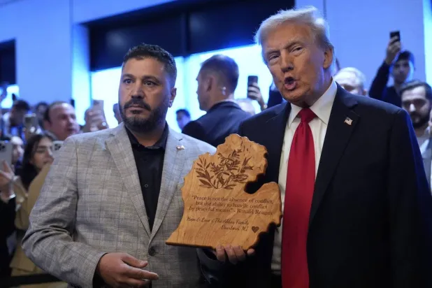 Albert Abbas hands US President-elect Donald Trump the commemorative plaque. (AFP)