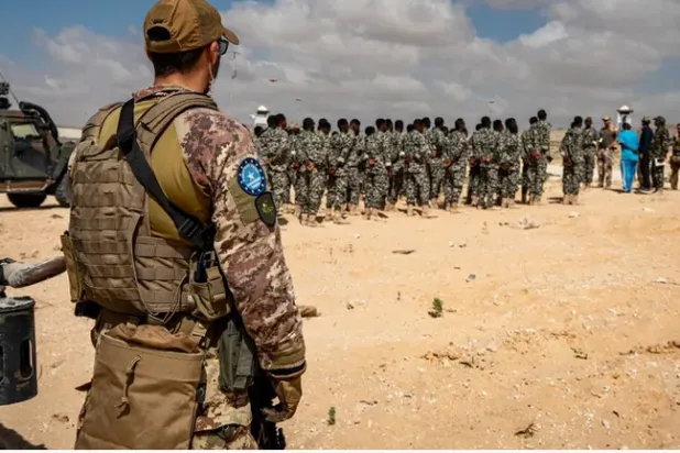 جندي من بعثة تدريب الاتحاد الأوروبي في الصومال (EUTM-S) يراقب إحاطة صباحية عُقدت لقوات الجيش الصومالي (SOCAC) في مركز تدريب الجنرال دجابادان في مقديشو يوم 19 مارس 2024 (أرشيفية- أ.ف.ب)