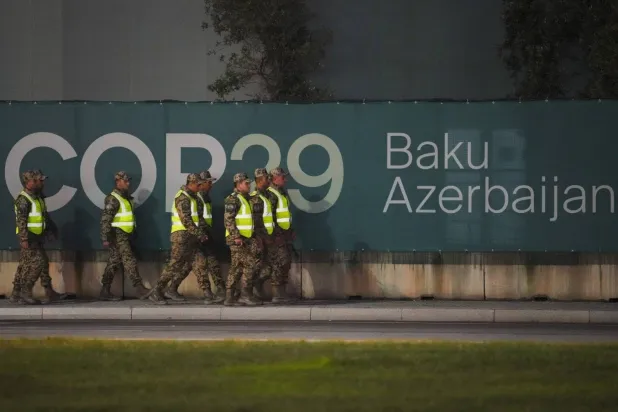 Security personnel walk outside the venue of the COP29 conference. (AP) 