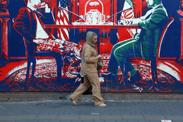 إيرانية تمرّ أمام رسمة جدارية على حائط السفارة الأميركية السابقة في طهران الأسبوع الماضي (إ.ب.أ)