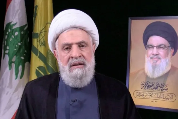 أمين عام "حزب الله" نعيم قاسم يتحدث عبر الشاشة (رويترز)