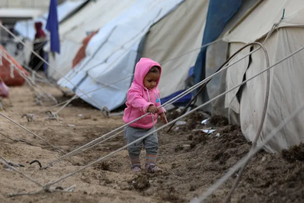 طفل وسط مخيمات النازحين في وسط غزة (رويترز)