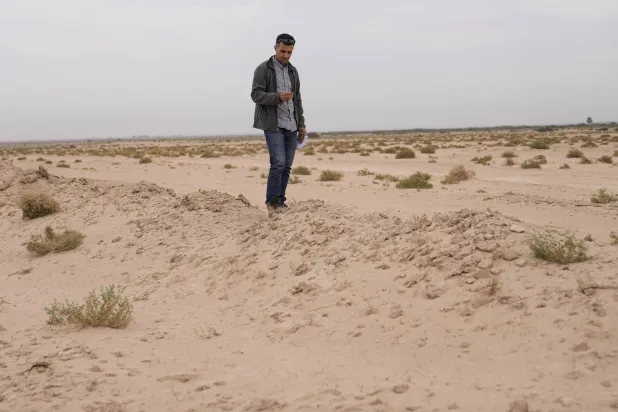 د. جعفر الجوثري يحمل صور الأقمار الاصطناعية ويستكشف موقع معركة القادسية (أ.ب)