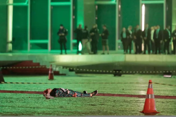 جثة الشخص الذي قُتل جراء أحد الانفجارين أمام ساحة أمام المحكمة (أ.ف.ب)