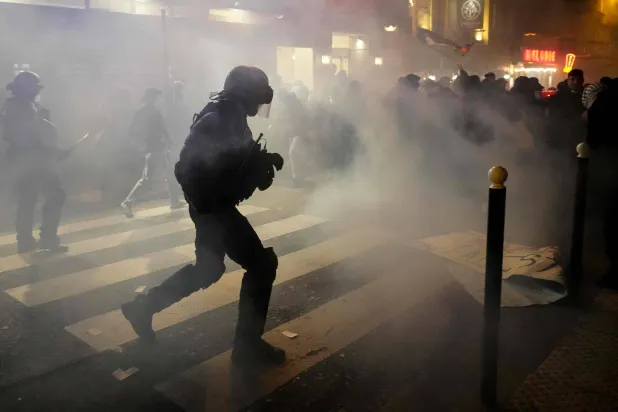 تصاعد الدخان المتصاعد خلال اشتباك المتظاهرين مع قوات فرنسية خلال مسيرة ضد مهرجان «إسرائيل إلى الأبد» (أ.ف.ب)