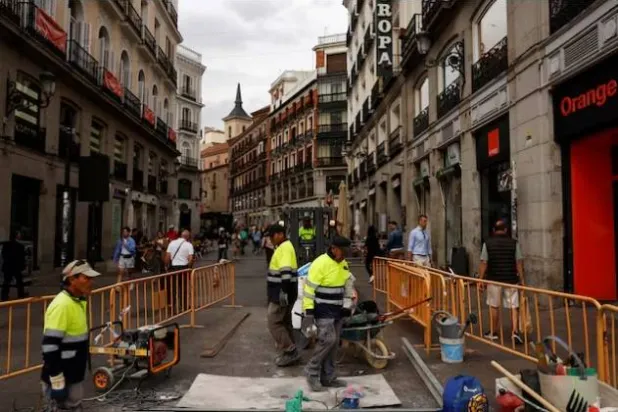 عمال يعملون في موقع بناء بوسط مدريد إسبانيا (رويترز)