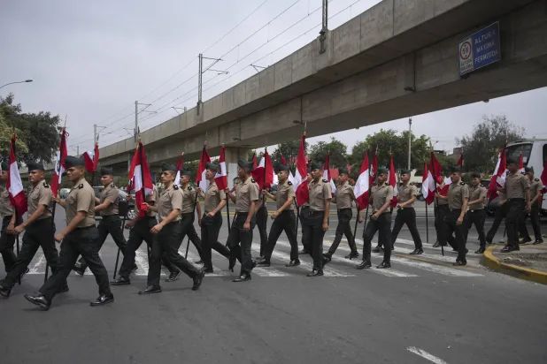 عناصر شرطة حاملين الأعلام الوطنية يتوجهون إلى وزارة الثقافة في البيرو مكان انعقاد قمة منتدى «آبيك» في ليما 15 نوفمبر 2024 (أ.ب)