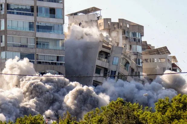 مبنى يتداعى إثر ضربة  إسرائيلية في منطقة الغبيري جنوب بيروت أمس (أ.ف.ب)