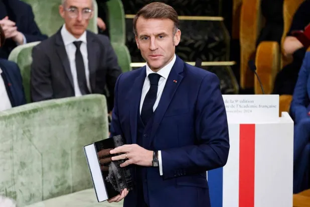France's President Emmanuel Macron holds the 9th edition of the Dictionnaire de l'Academie Francaise (Dictionary of the French Academy), which is the official dictionary of the French language during the solemn session of presentation, in Paris on November 14, 2024. (AFP)