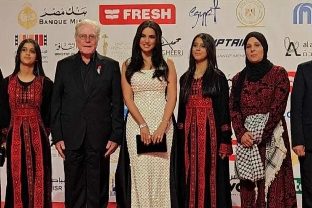 الممثلة التونسية درة وعلى يمينها حسين فهمي رئيس مهرجان القاهرة السينمائي مع أبطال فيلم «وين صرنا؟» خلال عرضه الأول في المهرجان أمس (إكس)