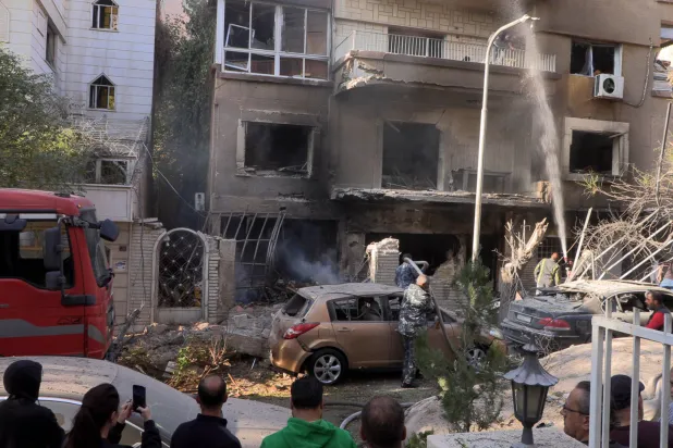 قوات أمن سورية في موقع غارة إسرائيلية استهدفت حي المزة في دمشق (إ.ب.أ)