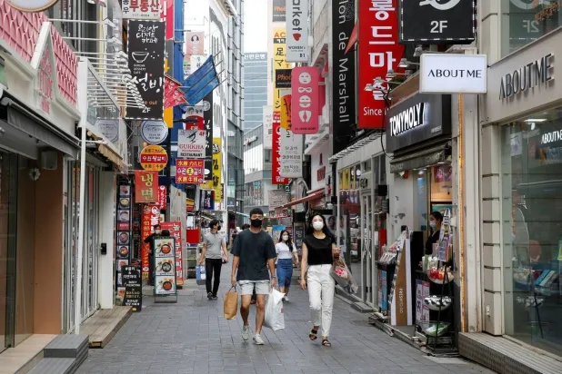 متسوقون في أحد الشوارع التجارية بالعاصمة الكورية الجنوبية سيول (رويترز) 