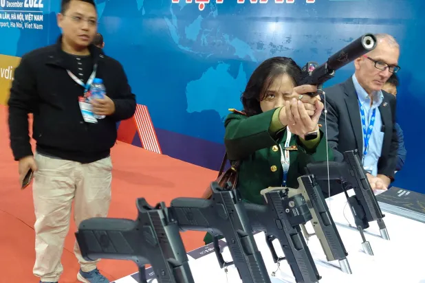 ضابطة فيتنامية تجرب سلاحاً خلال معرض الدفاع الدولي في هانوي (أرشيفية-رويترز)