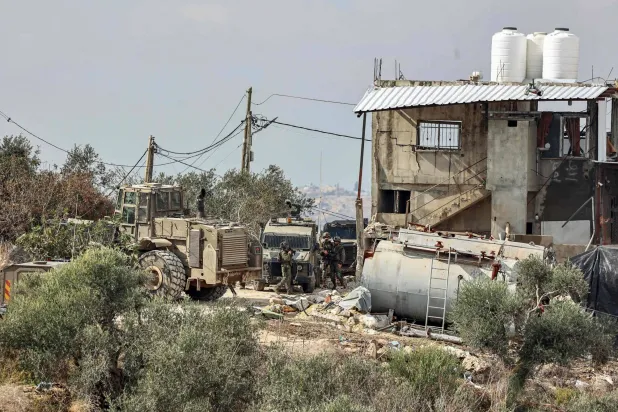 قوات إسرائيلية حول منشأة زراعية ومنزل بعد مداهمة قُتل خلالها 3 فلسطينيين في قباطية جنوب جنين بالضفة الغربية المحتلة يوم الثلاثاء (أ.ف.ب)