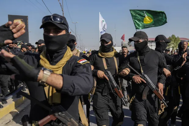 عناصر فصيل مسلح في جنازة رفاق لهم قضوا في ضربة أميركية بمحافظة بابل مؤخراً (أ.ب)