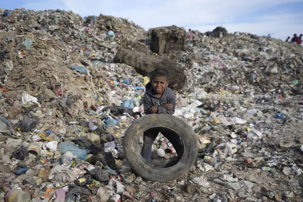 طفل فلسطيني أثناء فرز القمامة في مكب نفايات بقطاع غزة (أ.ب)