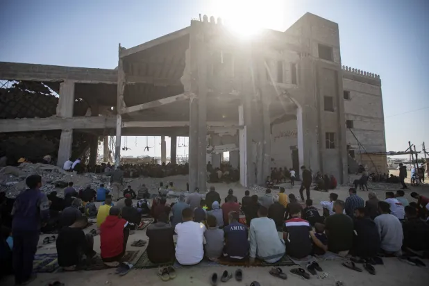 فلسطينيون يؤدون صلاة الجمعة على أنقاض مسجد مدمر في خان يونس بجنوب قطاع غزة (إ.ب.أ)