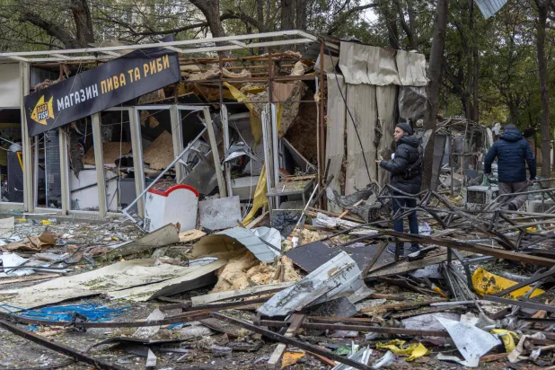 سكان أمام منزل متضرر بهجوم طائرة مسيّرة في منطقة أوديسا جنوب أوكرانيا (أ.ف.ب)