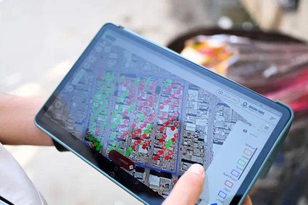 موظف عراقي يتصفح جهازاً لوحياً لإجراء التعداد السكاني (أ.ف.ب)