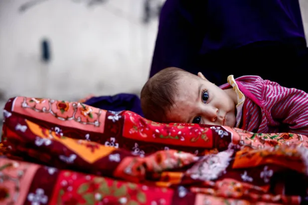 طفل يراقب ماذا يحصل حوله بينما تحاول عناصر أمنية طرد النازحين من فندق قديم بمنطقة الحمرا في بيروت (رويترز)