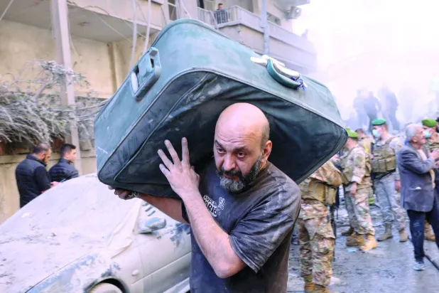 İsrail’in dünkü saldırısının ardından Beyrut'taki Basta bölgesinden ayrılan Lübnanlı bir adam (Reuters)
