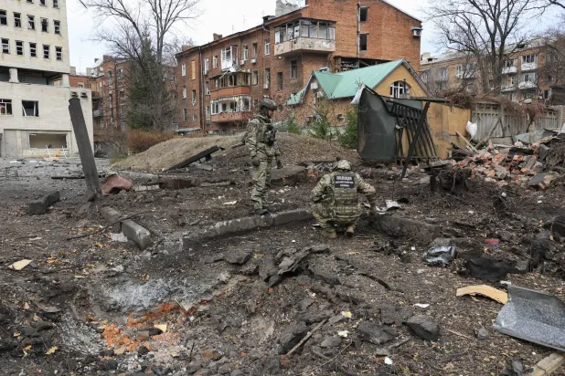 خبراء أوكرانيون يتفقدون الأضرار في موقع الهجوم الصاروخي الذي ضرب وسط خاركيف شمال شرقي أوكرانيا في 25 نوفمبر 2024 وسط الغزو الروسي للبلاد (إ.ب.أ)