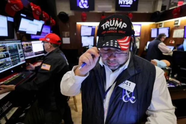 متداول في بورصة نيويورك يرتدي قبعة دعماً للجمهوري دونالد ترمب بعد فوزه بالانتخابات الرئاسية الأميركية (رويترز)