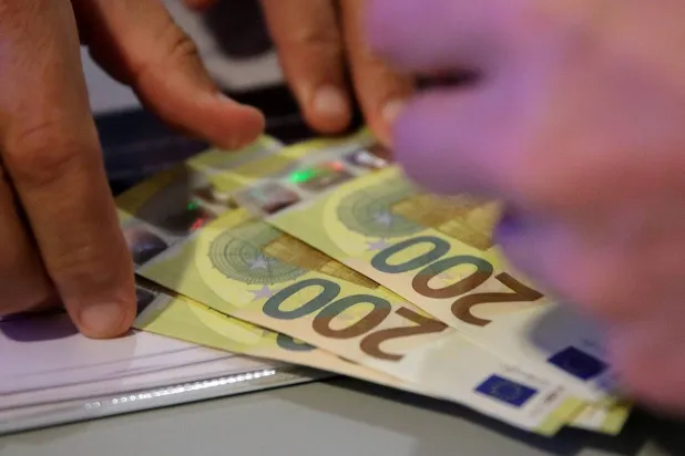 مسؤول في البنك المركزي النمساوي يتسلم أوراقاً نقدية جديدة من فئة 200 يورو (رويترز)