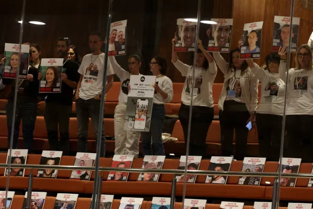 عائلات وأنصار المحتجزين الإسرائيليين يحملون ملصقات أثناء مناقشة الموضوع في الكنيست الإسرائيلي في القدس 18 نوفمبر 2024 (رويترز)