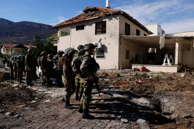 عناصر من الجيش الإسرائيلي يقفون خارج منزل أصيب بصواريخ أطلقها «حزب الله» من لبنان على بلدة كريات شمونة الحدودية شمال إسرائيل... 26 نوفمبر 2024 (أ.ف.ب)