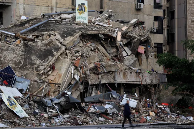 A man walks past near the rubble of a building in Beirut's southern suburbs, after the ceasefire between Israel and Hezbollah, Lebanon November 29, 2024. REUTERS/Thaier Al-Sudani