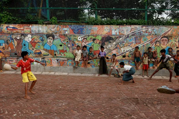 أولاد من اللاجئين الروهينغا يلعبون داخل مخيم للاجئين في بنغلادش (رويترز)