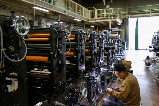 عامل يصلح الأسلاك في مصنع بالصين (رويترز)