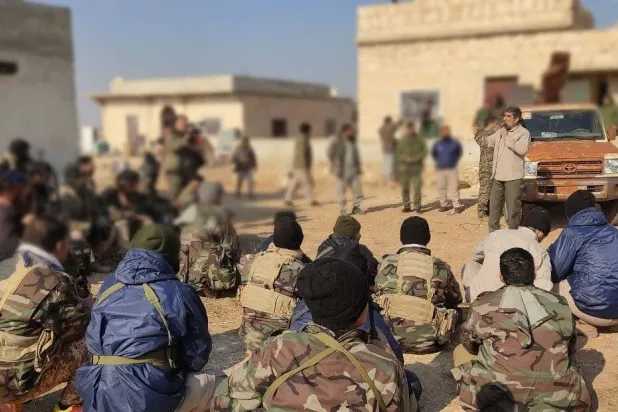 المنشد مهدي سلحشور التابع لـ«الحرس الثوري» وهو يردد أناشيد لمجموعة من مقاتلي ميليشيا «فاطميون» في ضواحي حلب (مهر)